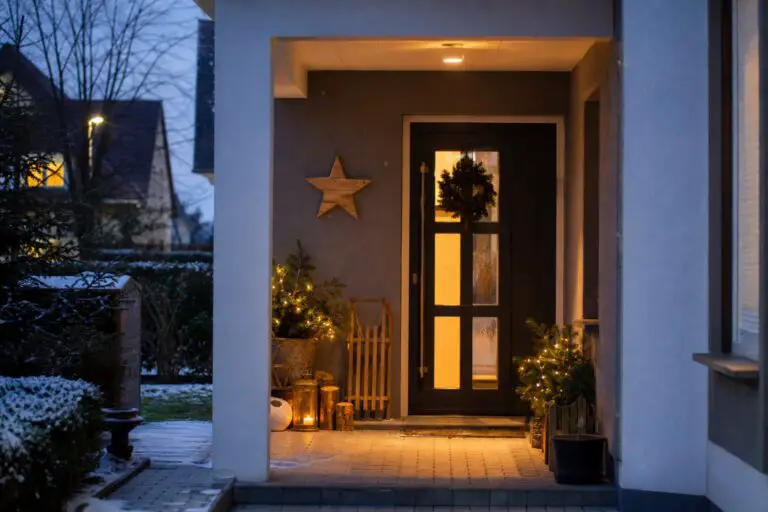 Weihnachtlich dekorierter deutscher Hauseingang mit Holzsternen, Tannengrün und warmem Licht