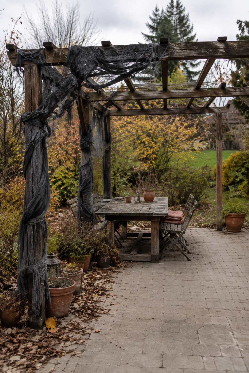 Dunkler zerrissener Horrorstoff hängt sicher an einer Seite einer Holzpergola