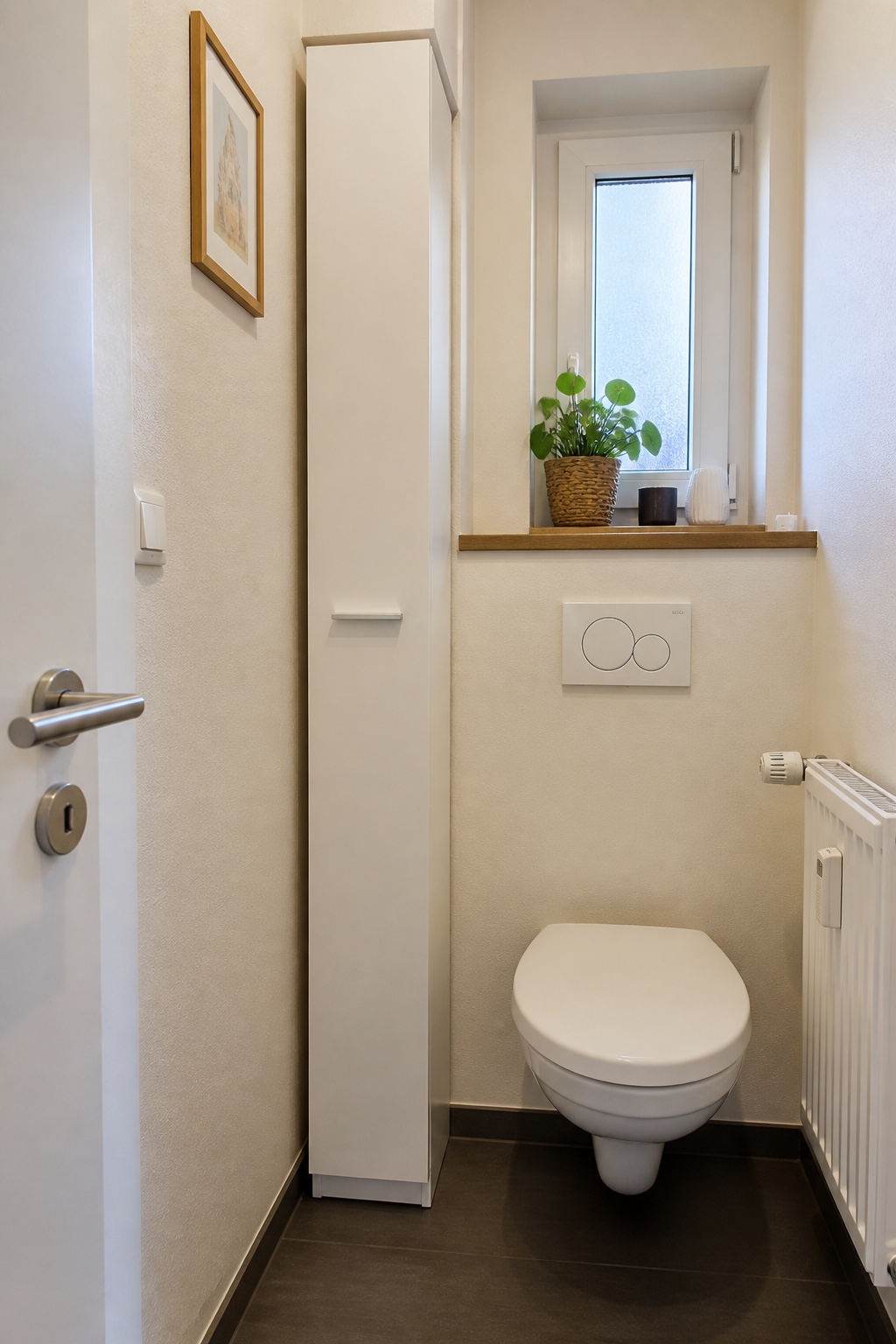Sehr schmaler hoher Badschrank in einer Nische neben dem WC