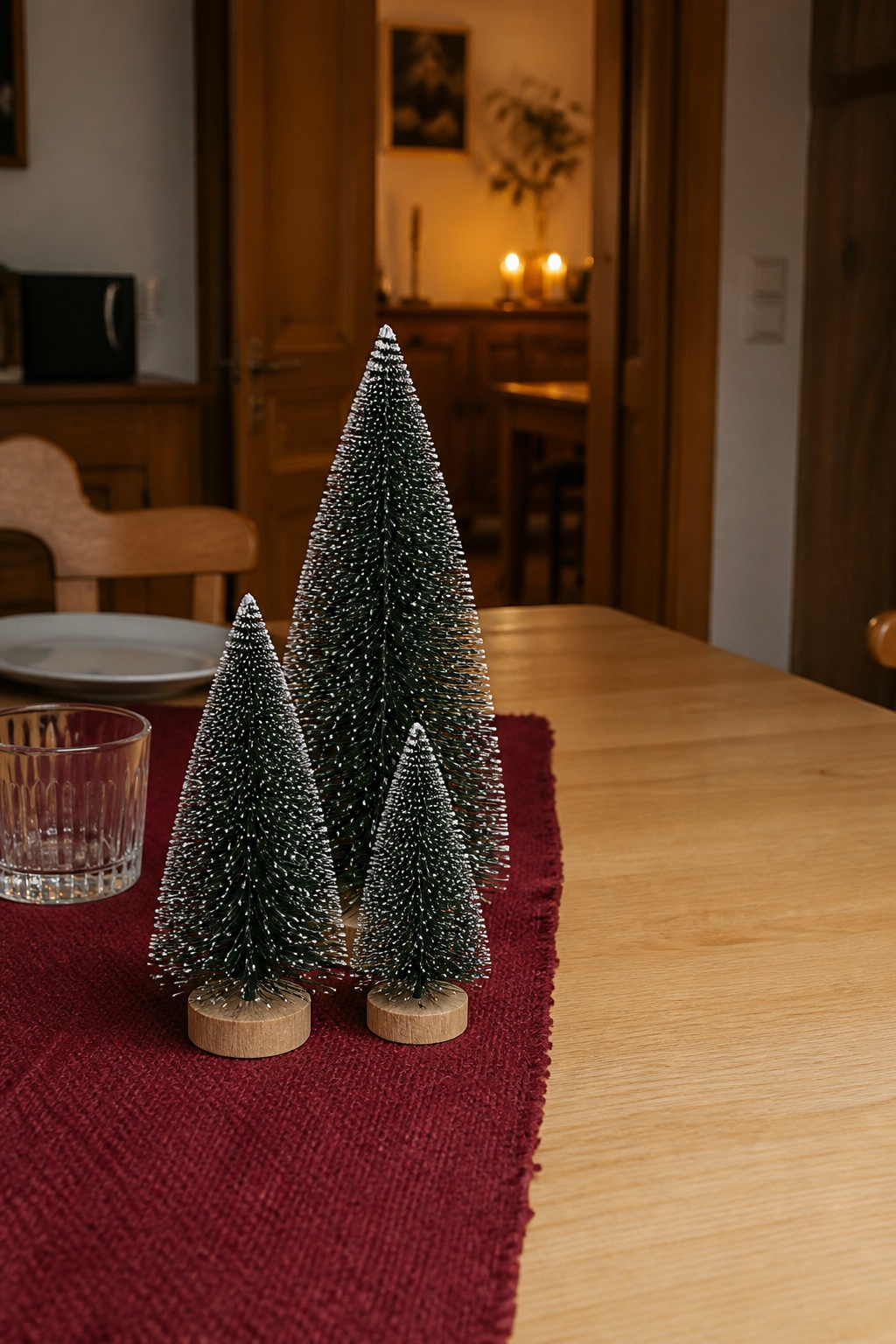 Kleine Tannenbäume in drei Höhen als schmaler Winterwald auf dem Esstisch