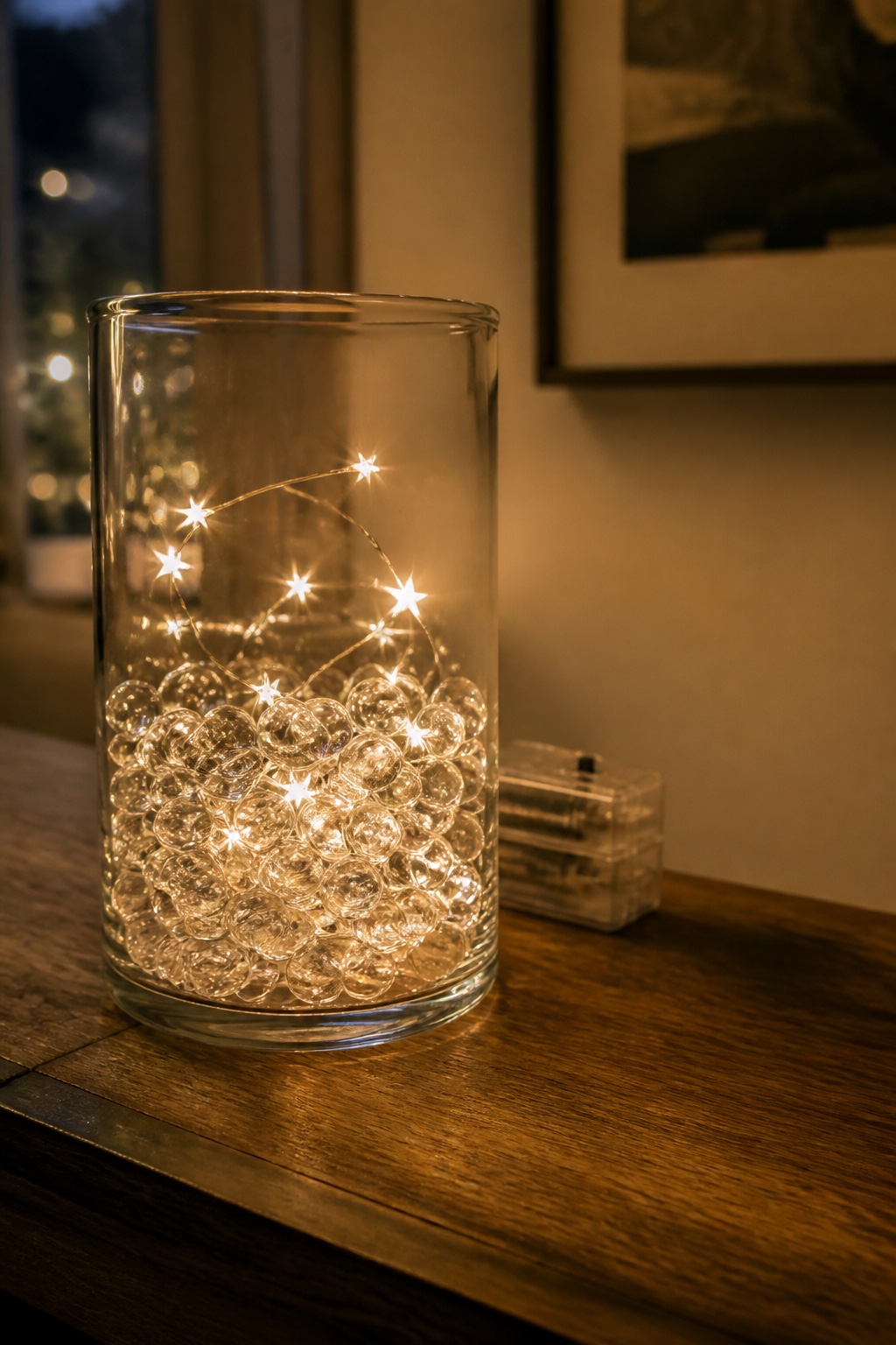 Hohes Glas mit klaren Wasserperlen und warmweißem Sternlicht